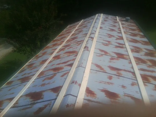 Rusted metal roof panels with new wood purlins before replacement — Storm Damage Roof Repair in West Hartford by Roofing Brothers