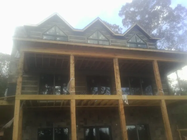 Dormers and porch framing on a large log home under construction — Roof Coating work by our crew in West Hartford