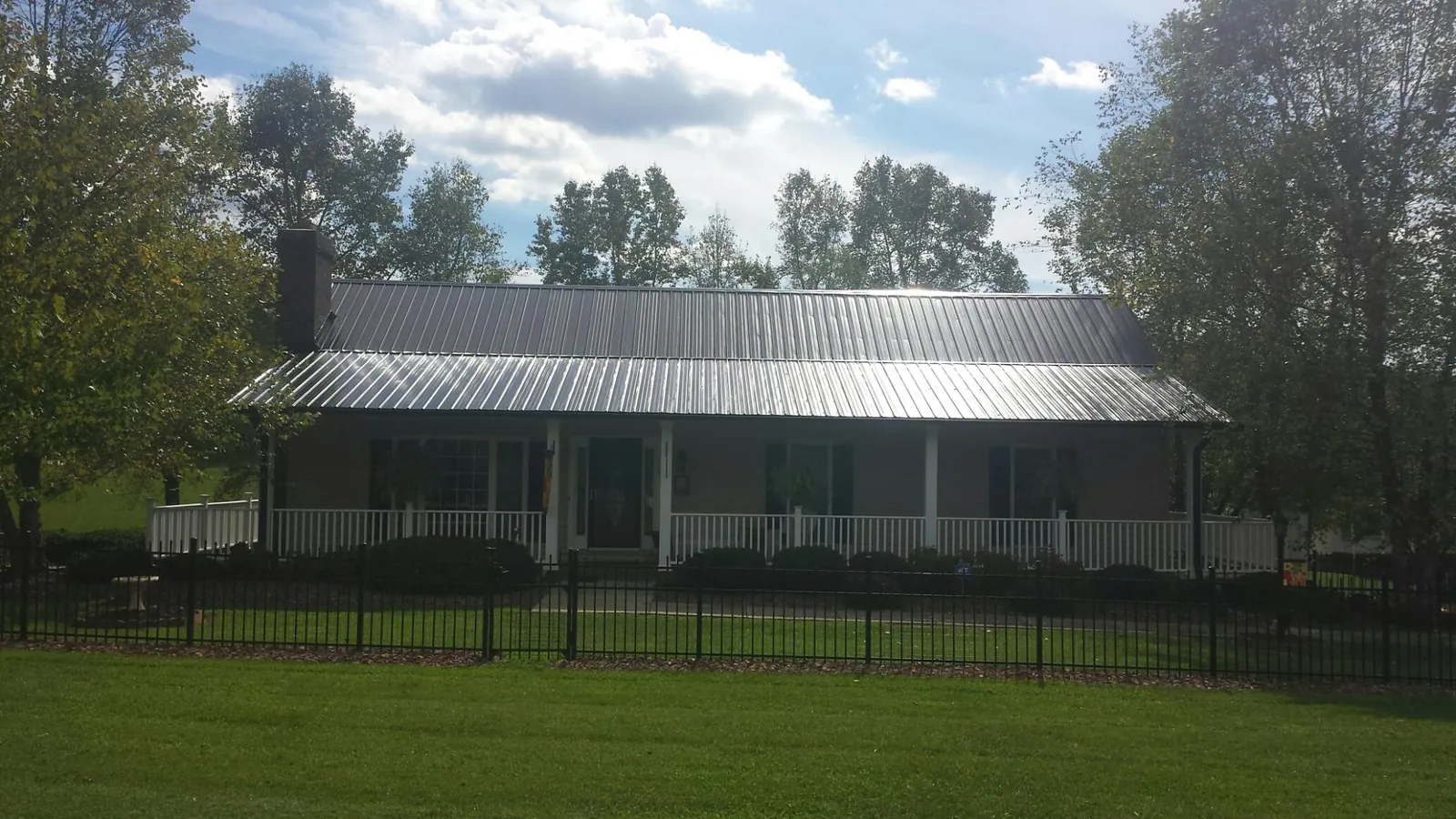 Gray metal roof on a brick ranch with a full width front porch — Gutter Guard Installation work by our crew in West Hartford